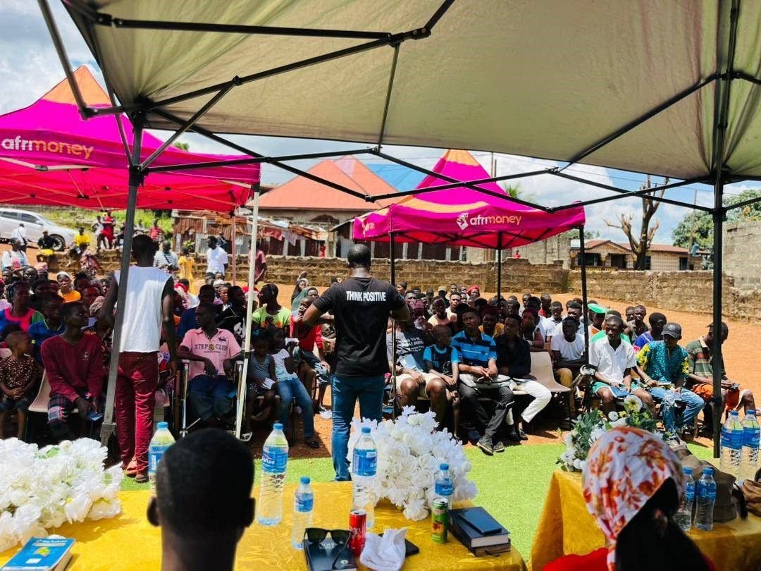 Abdulai addressing a large outdoor crowd under tents